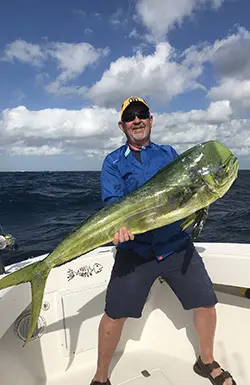 Angler holding a bright green and gold mahi-mahi