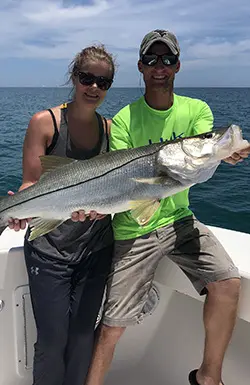 Couple holding a snook on an inshore charter