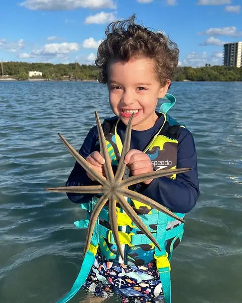Boy holding a starfish during a snorkel stop