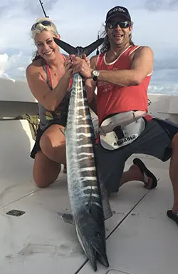 Couple showing off a long wahoo caught trolling offshore