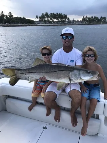 Family holding a big snook caught on an inshore trip